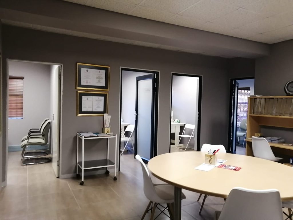 Private consultation room at Reproductive Choices SA featuring medical qualifications and professional certificates displayed on the wall.
